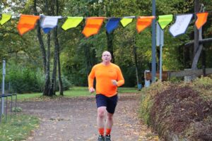 Chris running in his bright orange JOG ON long-sleeved top.