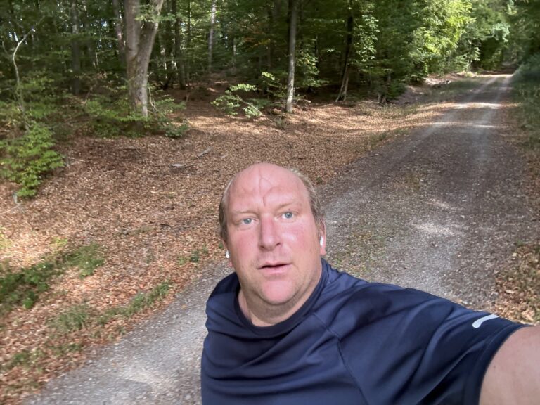 Chris taking a selfie during a run on a woodland path.